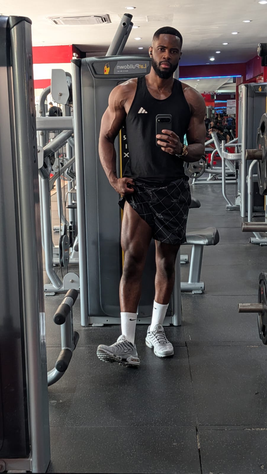 Farai Fitness coach posing in a gym mirror