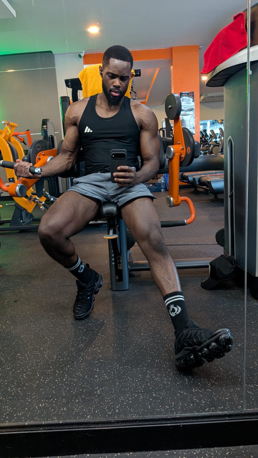 Farai Fitness coach training on a seated machine